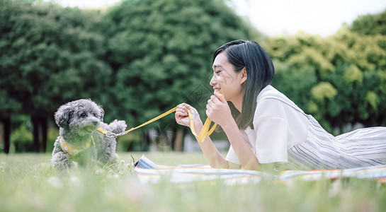 公园带着宠物游玩的女人图片