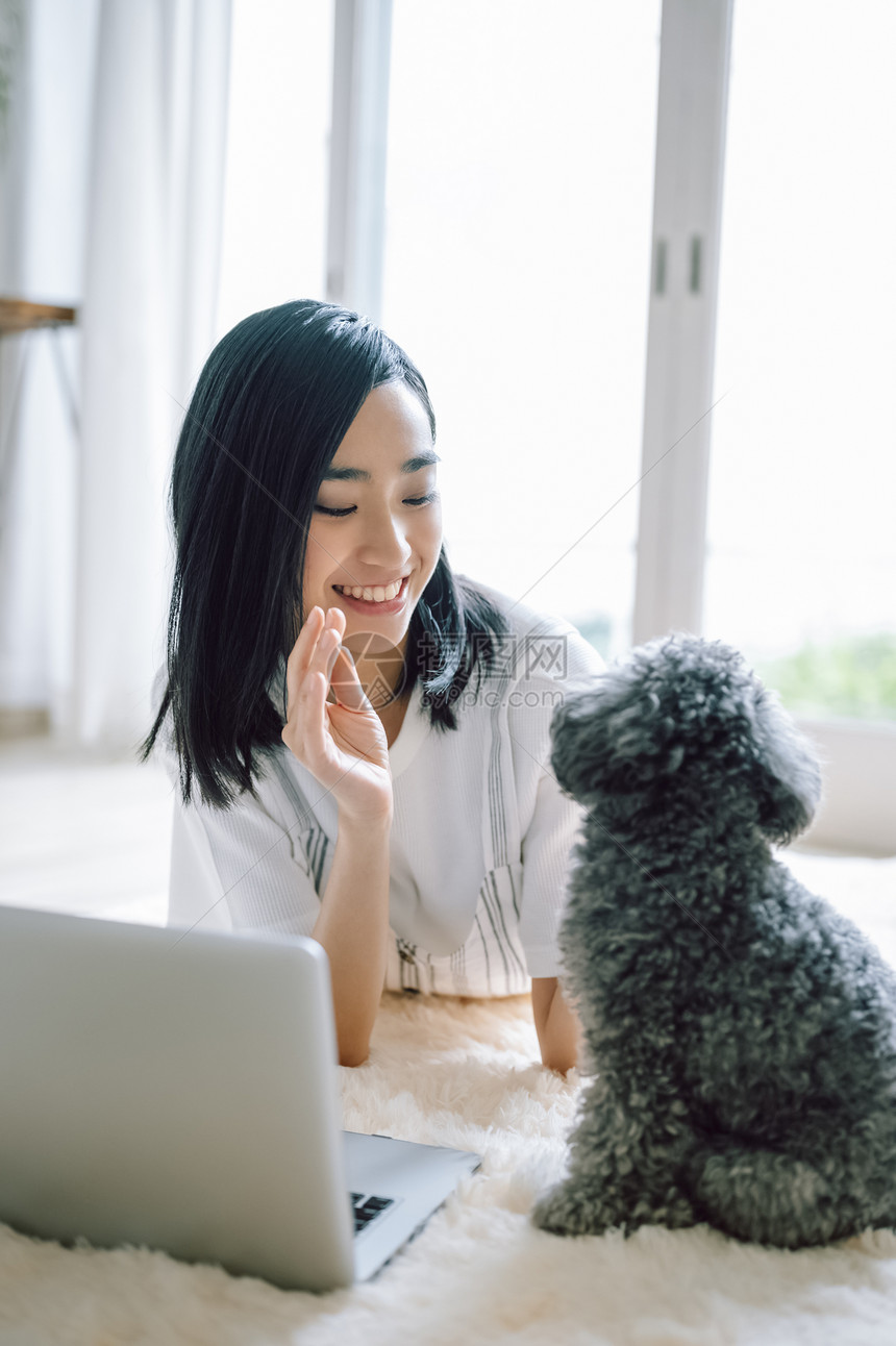 居家办公养宠物狗的女人图片