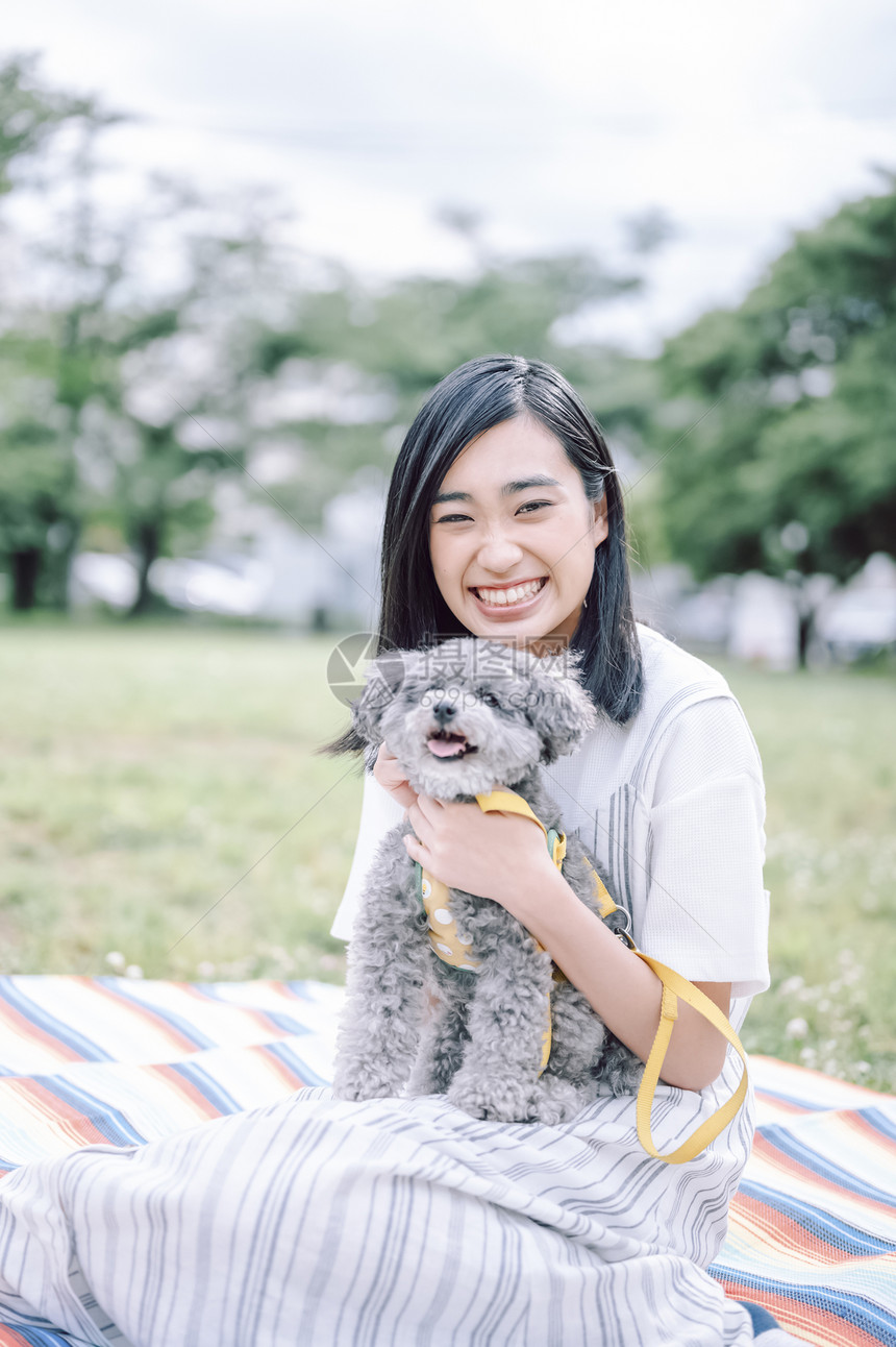 公园里带着宠物狗的女人图片