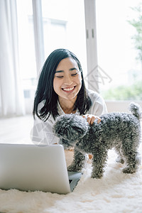 居家办公养宠物狗的女人图片