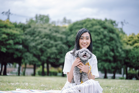 公园里带着宠物狗的女人图片