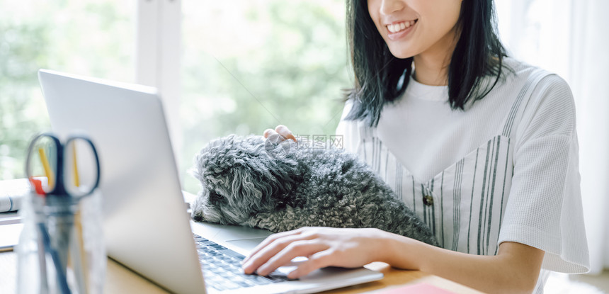 居家办公养宠物狗的女人图片