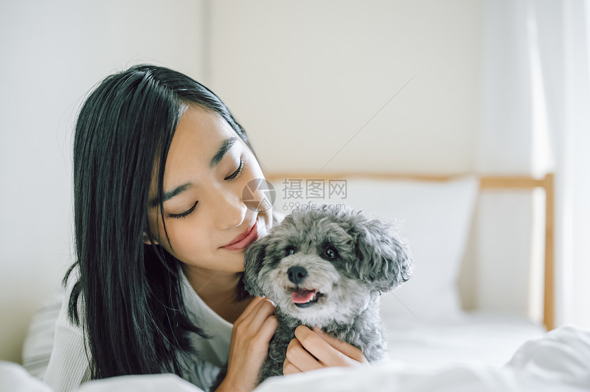 室内微笑的女人抱着宠物狗图片