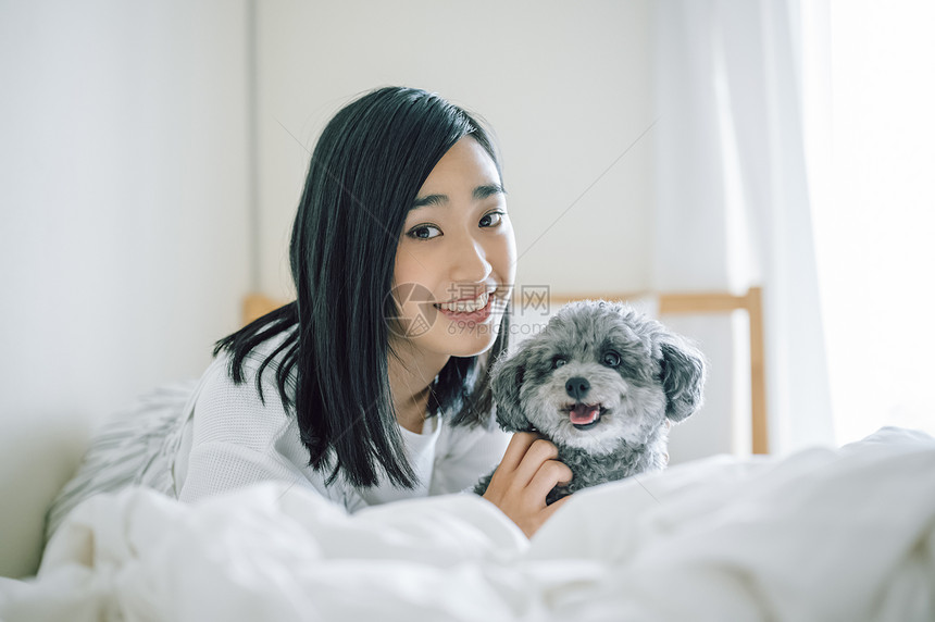 室内微笑的女人抱着宠物狗图片