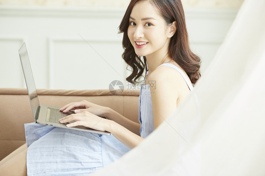 居家使用笔记本电脑的年轻女子图片