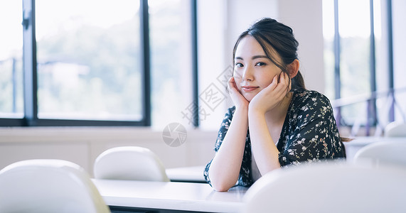 手托下巴大学教室里的女大学生背景