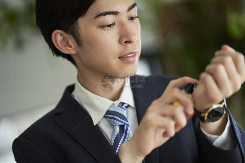 室内西装的男子喷香水图片