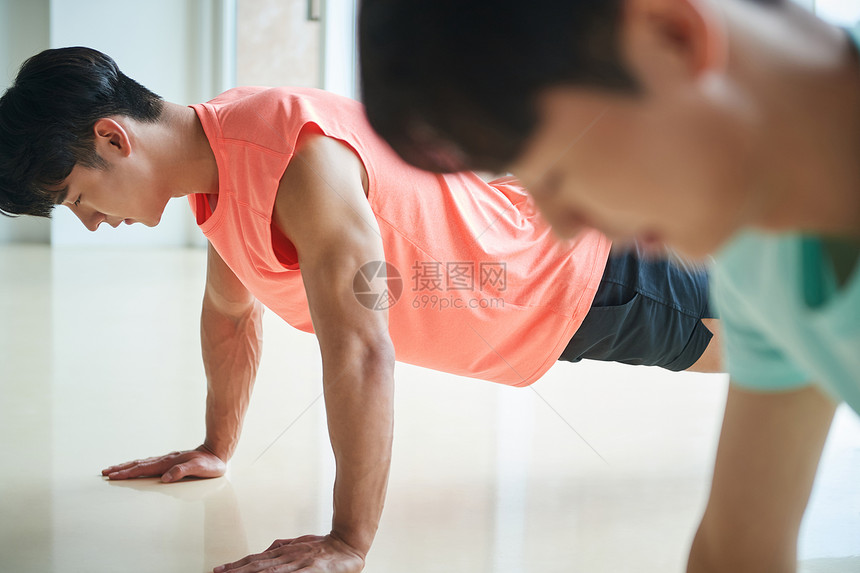 年轻男士穿运动装做俯卧撑锻炼图片