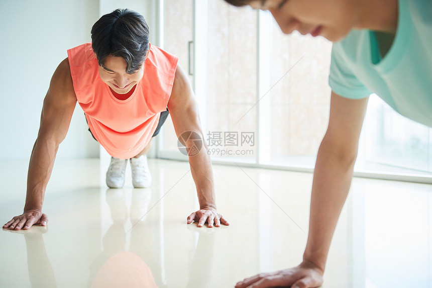 年轻男士穿运动装做俯卧撑锻炼图片