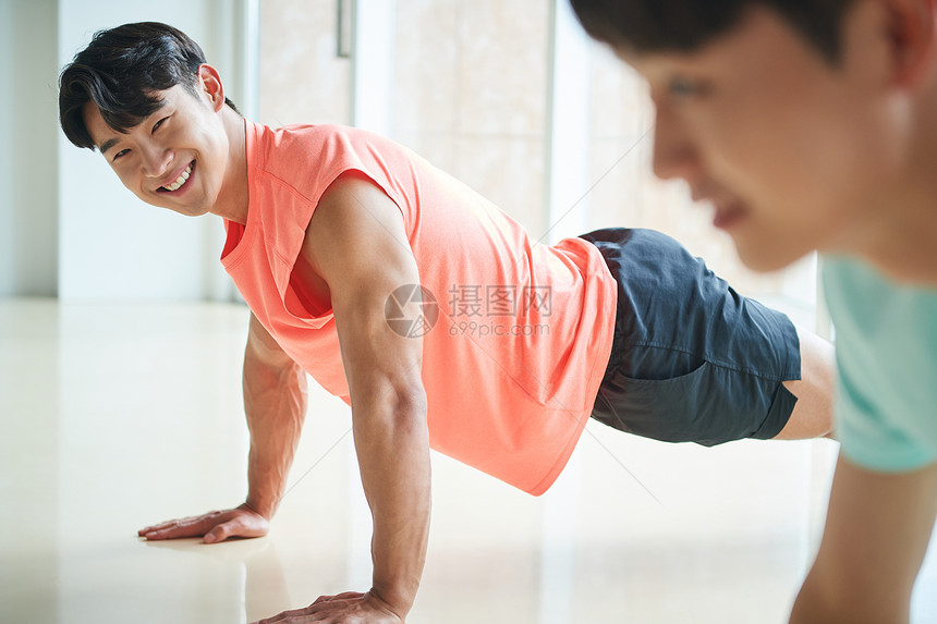 年轻男士穿运动装做俯卧撑锻炼图片