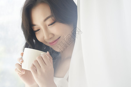 室内休闲喝茶的可爱女生图片