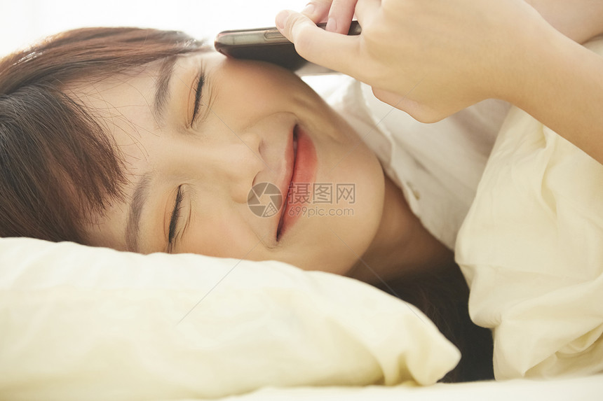可爱女生开心的在床上讲电话图片