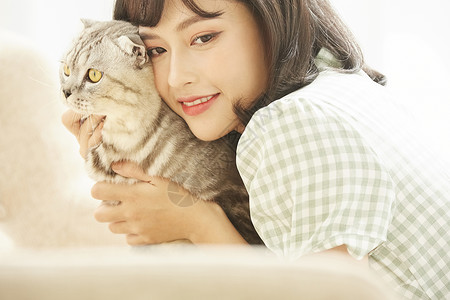 侧脸的猫美女抱着宠物猫背景