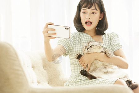 抱着猫猫自拍的年轻女子图片