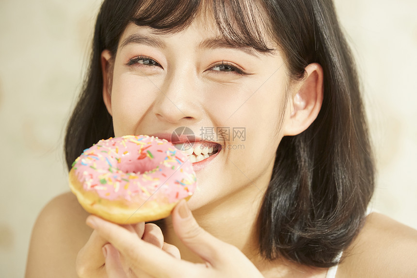 吃甜甜圈的年轻女子图片
