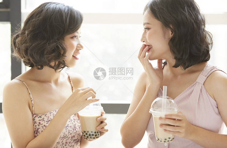 亲密姐妹开心的喝奶茶图片