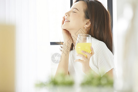 窗边喝饮料的年轻女人图片