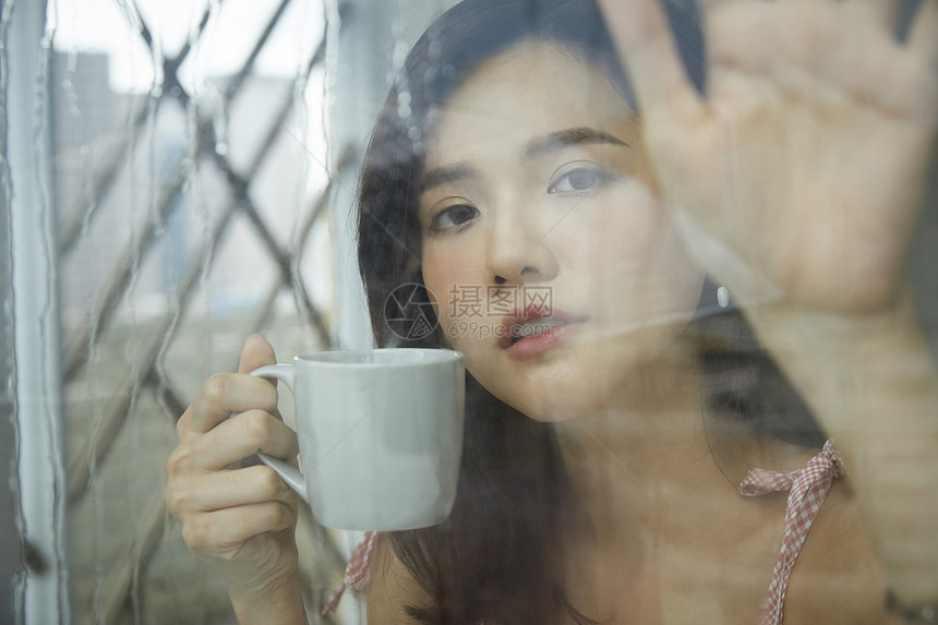 下雨天喝咖啡的年轻女孩图片