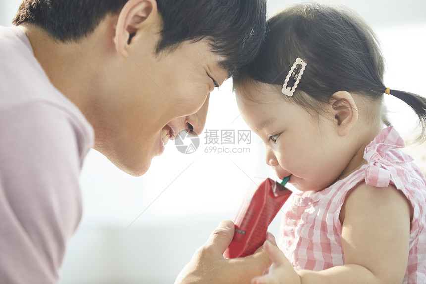 休闲笑脸泛亚洲父母和孩子的生活方式喝图片