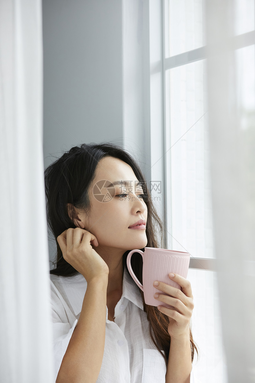 窗边喝茶的女人图片
