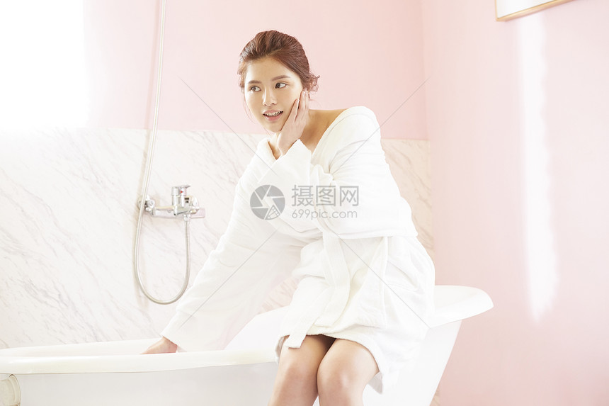 浴室里穿着浴袍的年轻女子图片