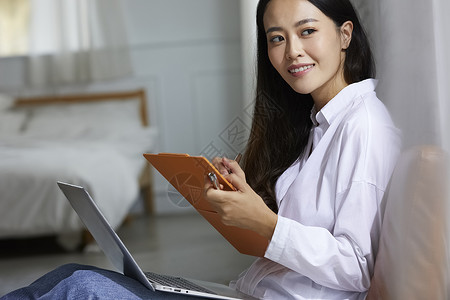 拿着文件夹记录的职业女性图片