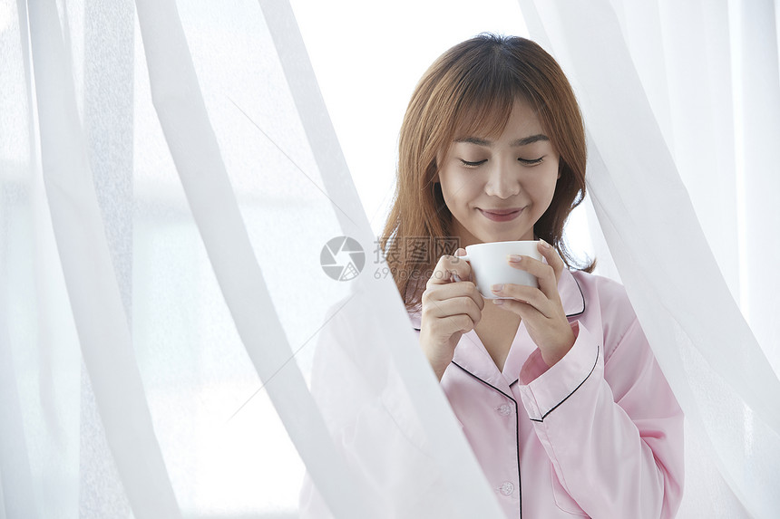 穿着睡衣喝咖啡的年轻女孩图片