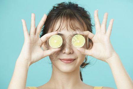 可爱女孩举着柠檬挡着眼睛图片