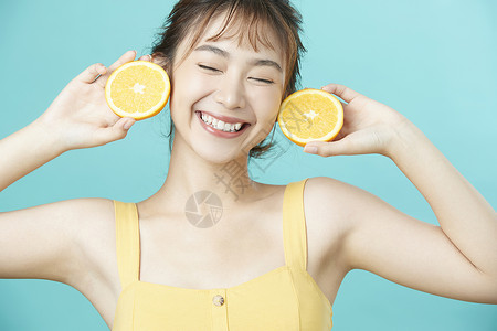 橘子的眼睛可爱女孩开心举着橙子背景