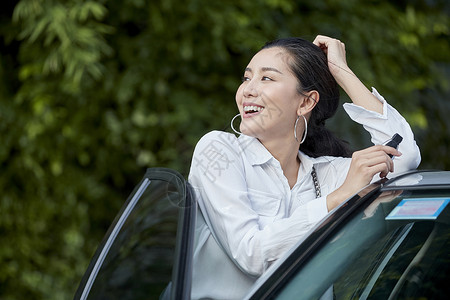 女人站在车边接打电话图片