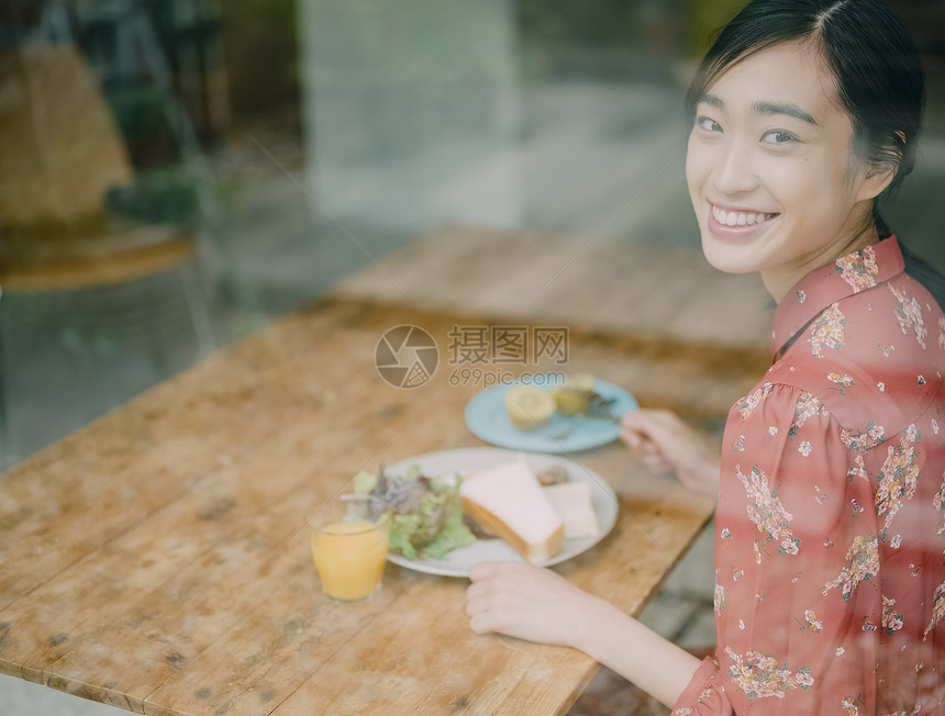 室内用餐的年轻女人看向窗外图片