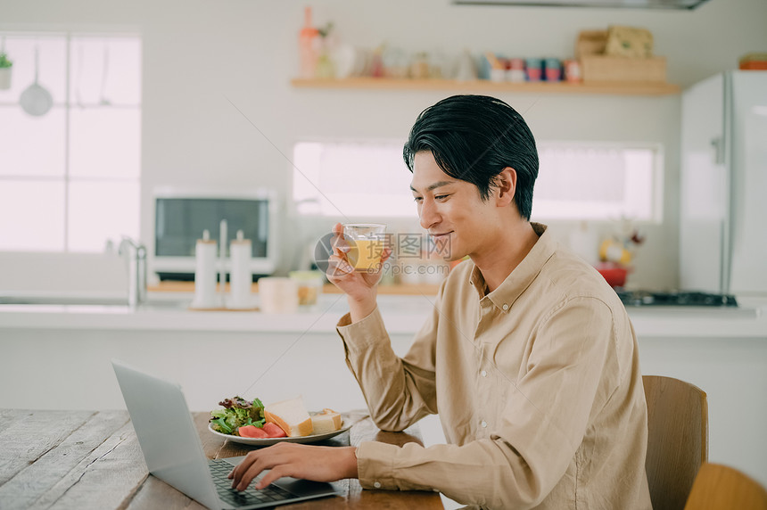 休假男子用餐使用笔记本电脑图片