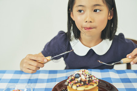 餐桌上吃甜点的小女孩图片