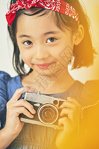 可爱的小女孩拿着照相机背景图片