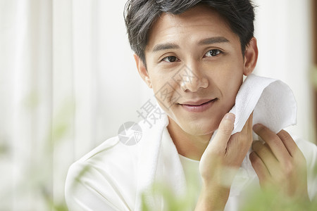 毛巾擦脸的成年男子图片