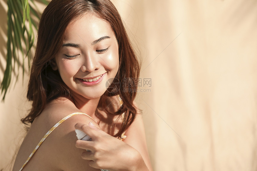 年轻女性使用防晒喷雾图片