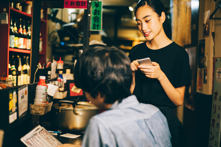 夜晚酒吧给顾客点餐的女人图片