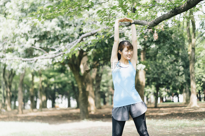 户外公园运动拉伸锻炼的年轻女子图片