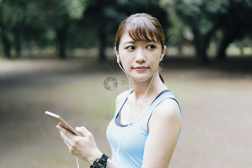 户外运动拿着手机的年轻女子图片