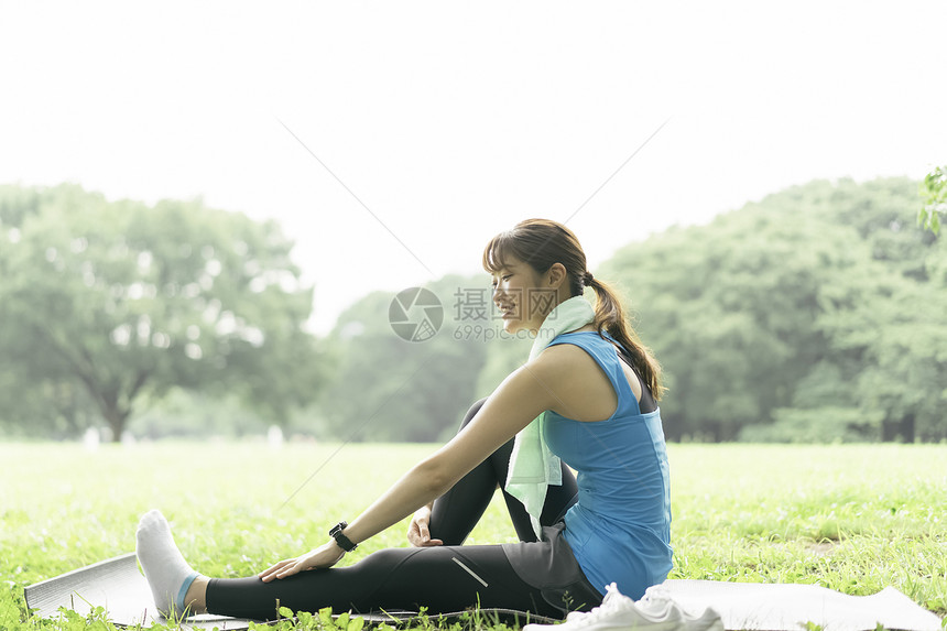 户外坐在瑜伽垫上休息的运动女性图片
