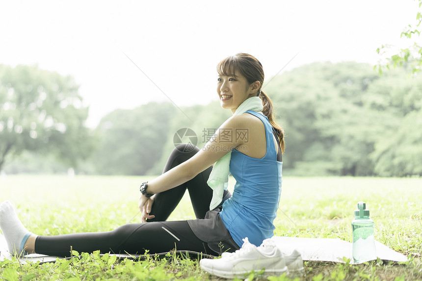 草坪上坐着休息的瑜伽女性图片