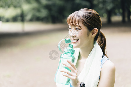 抱着水瓶女孩抱着水瓶喝水的女青年背景