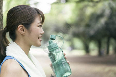 拿着水瓶喝水的女青年图片