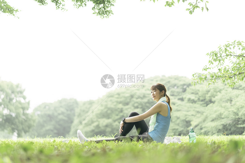 户外草坪上休息的年轻女子图片