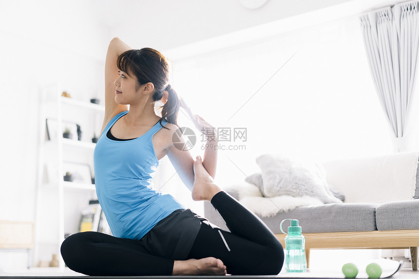 居家瑜伽锻炼的青年女子图片