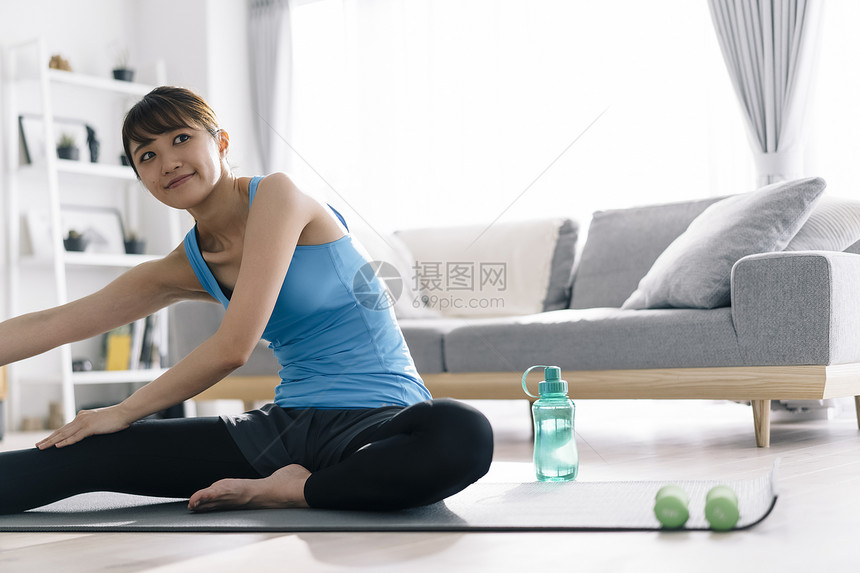 居家瑜伽锻炼的青年女子图片