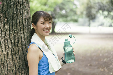公园喝水休息的运动女青年图片