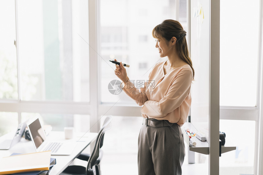 拿着记号笔的商务女性图片