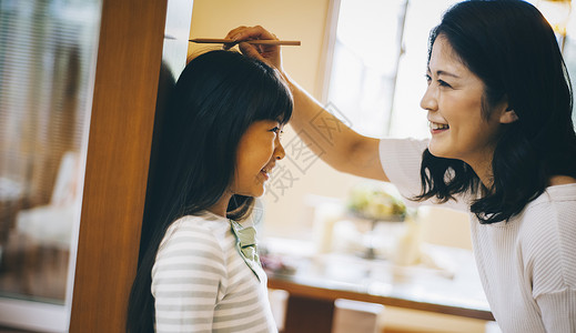 家里量女儿身高的妈妈背景图片