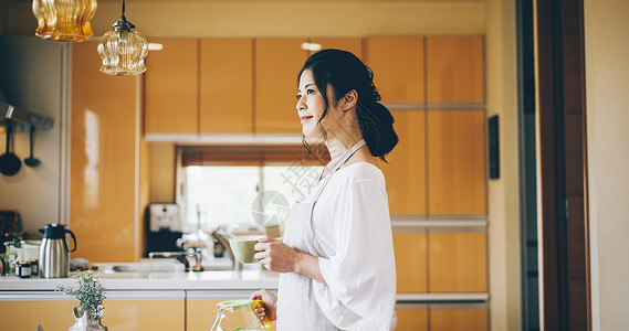 厨房里休闲喝茶的女人图片